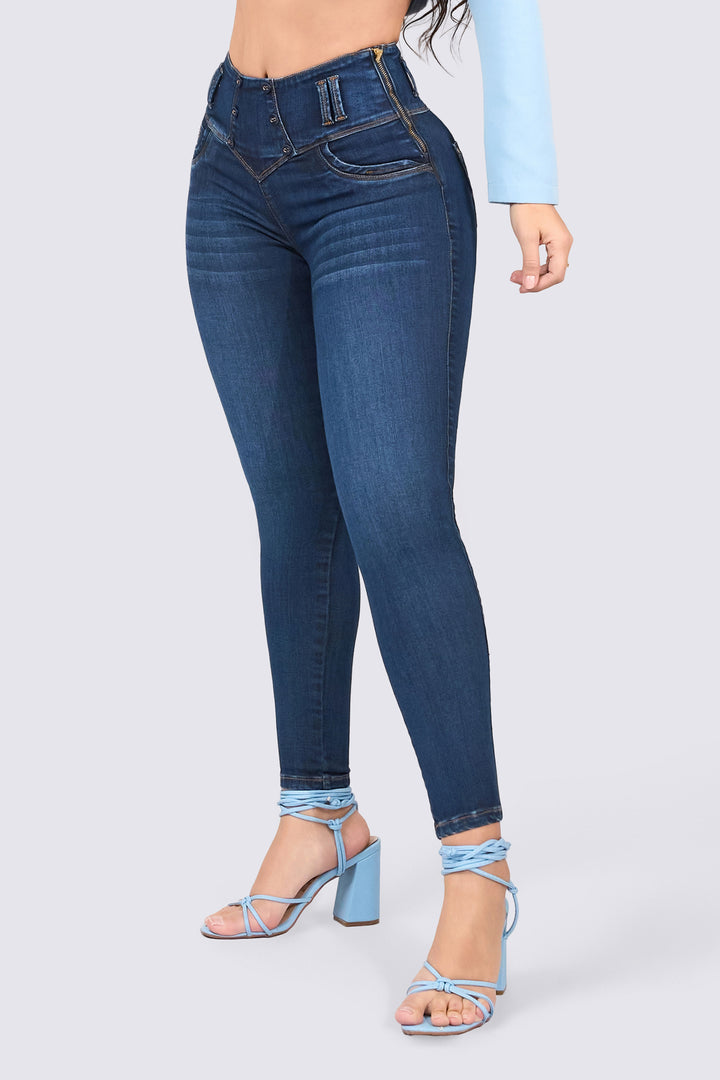 Dark blue skinny jeans, mid-rise, with back pockets, a waistband design, and a slim fit. 