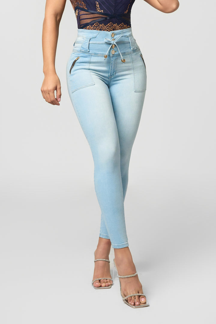 Tummy control high-waisted skinny jeans in light wash. Curve-enhancing fit with lace-up front and zip pockets.