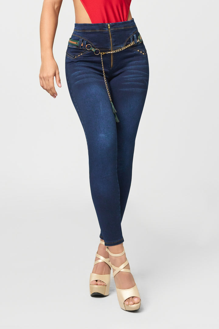Dark wash skinny jeans color azul, de tiro alto, cadena decorativa y cierre frontal.